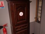 une grande armoire en bois surmontée d'un extincteur
