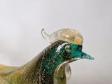 a glass sculpture of a bird on a white surface
