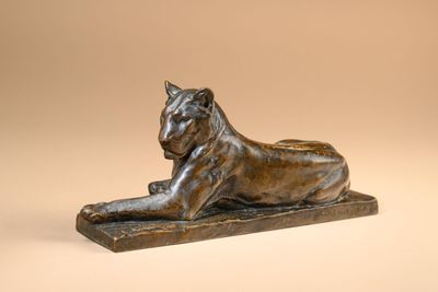 a bronze statue of a lion on a marble base