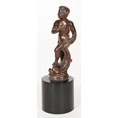 a bronze statue of a boy holding a fish on a pedestal