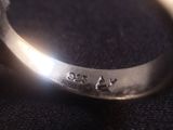 a close up of a silver ring with a diamond on it