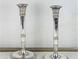deux bougeoirs en argent posés sur une table en marbre
