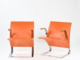 paire de fauteuils de salon en cuir orange, avec pieds et accoudoirs chromés