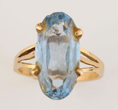 Gros plan sur une bague en or ornée d'une topaze bleue