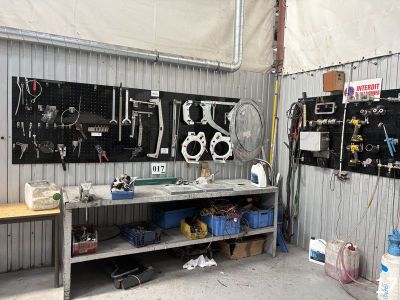 Il y a de nombreux outils accrochés au mur dans ce garage.