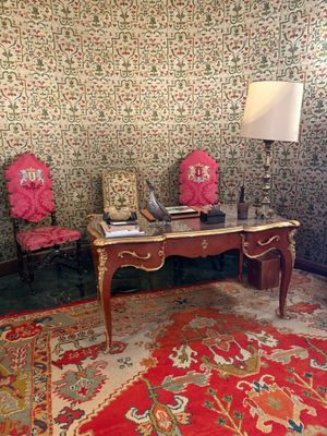 deux chaises et un bureau dans une pièce au papier peint à motifs floraux