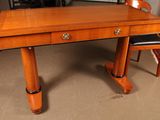 a wooden desk with two chairs and a rug