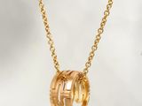 a gold plated necklace with three intertwined rings on a chain