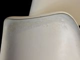 a close up of a white chair with a black background