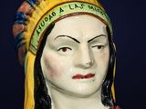 a statue of a woman wearing a headdress on a blue background