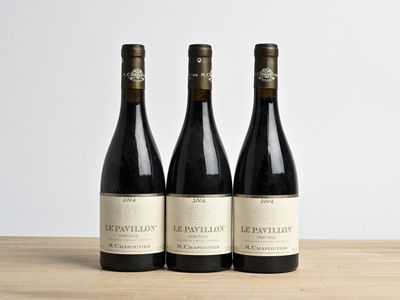 trois bouteilles de vin posées sur une table en bois