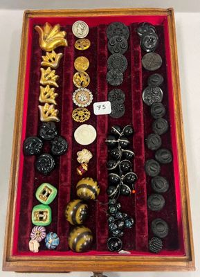 une boîte en bois remplie d'un assortiment de boutons et d'autres objets