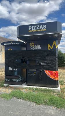 a pizza stand with a pizza on it in the middle of the road