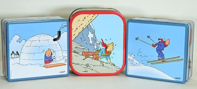 three tins with pictures of people skiing on them