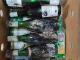 many empty bottles in a cardboard box on the floor