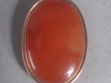an orange pendant with a rope hanging from it ' s side