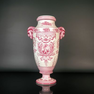 a pink and white vase sitting on a black table