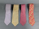 four different colored ties are lined up on a gray surface