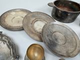 a lot of silver dishes and cups on the table