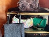 two bags and a purse sitting on a shelf