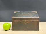 a green apple sitting next to an old metal box