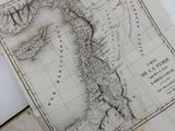an open book with a map on top of it sitting on a table