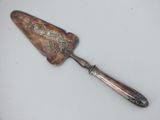 a silver spoon with a handle on a white surface