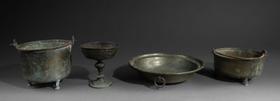 three bronze pots and a bowl on a table