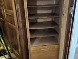 une grande armoire en bois avec un tiroir dans un coin