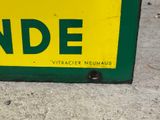 a yellow and green sign on the side of a building