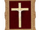 a gold framed crucifix with a red velvet background