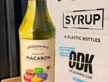 a bottle of macaron sitting on a table next to a box