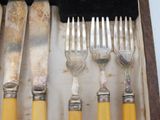 five forks and five knives in a wooden box