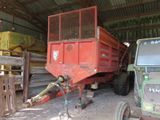 a tractor and a tractor trailer in a barn