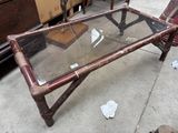 une table basse avec un plateau en verre posée sur un trottoir