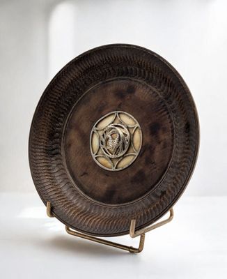 une plaque métallique ornée d'une rose, posée sur un socle