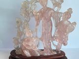 statue représentant une femme tenant un enfant dans ses bras, posée sur un socle en bois