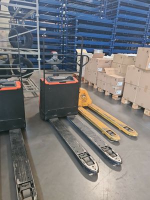 forklifts and pallets in a warehouse with boxes on the floor