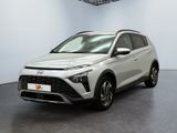 Une voiture blanche est garée dans une pièce équipée d'un ventilateur de plafond