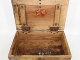 an old wooden box with a tag on the inside of it