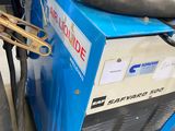 une machine bleue à laquelle est raccordé un tuyau sur le côté
