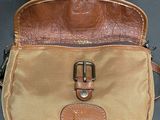 an image of a brown and tan purse on a black surface