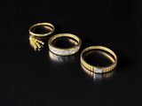 trois bagues en or serties de diamants sur fond noir