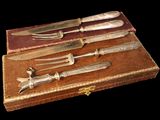 five knives and a fork in a box on a table
