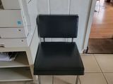 a black chair that is sitting in front of a printer
