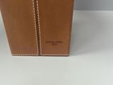 a brown leather bag sitting on top of a white table
