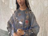 a statue of a woman holding a piece of bread in a glass case