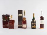 three bottles of liquor are lined up on a white surface