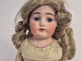 a small doll with blonde hair and blue eyes