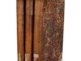 three old books sitting on top of each other on a white surface